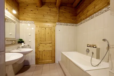 Helles Badezimmer mit Badewanne, zwei Waschbecken und Spiegel.