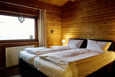 Blick in ein Schlafzimmer mit Doppelbett und Fenster.
