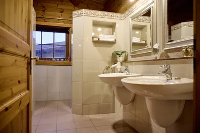 Helles Badezimmer mit Blick auf die zwei Waschbecken und Spiegel.