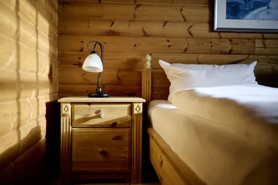 Nahaufnahme der linken Bettseite mit Nachttisch und Tischlampe.