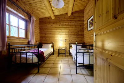 Blick in ein Schlafzimmer mit zwei Einzelbetten und großem Fenster.