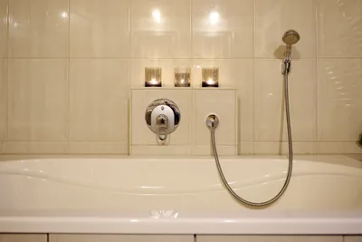 Helles Badezimmer mit Badewanne im Kerzenschein.