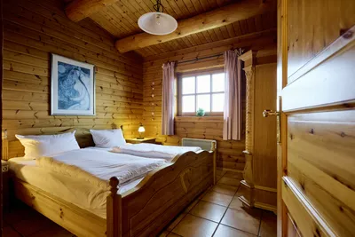 Blick in ein Schlafzimmer mit Doppelbett und großem Fenster.