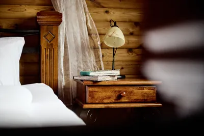 Nahaufnahme der rechten Bettseite mit Büchern und Lampe auf dem Nachttisch.