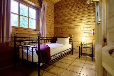 Gemütliches Schlafzimmer mit Blick auf ein Einzelbett und großem Fenster.
